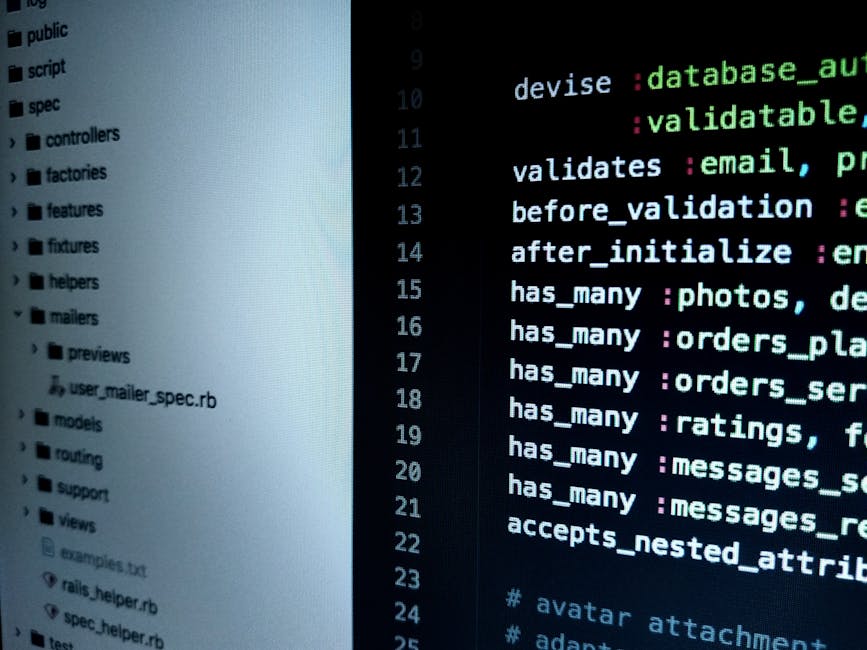 A close-up view of a laptop computer placed on a dark surface, displaying a screen filled with lines of code in a text editor. The screen shows a mixture of programming language syntax with highlighte